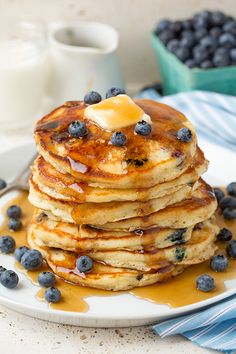 a stack of pancakes with butter and blueberries