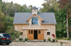 a car is parked in front of a barn