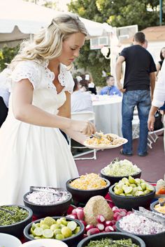 a woman in a white dress is serving food