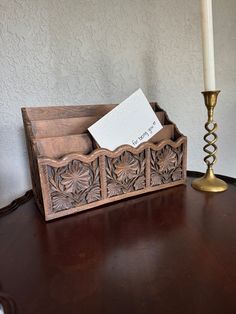 a desk with a pen holder, candle and note card holder on top of it