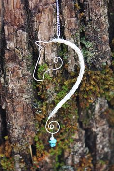 a piece of white wire hanging from a tree