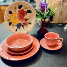 a table topped with pink plates and cups