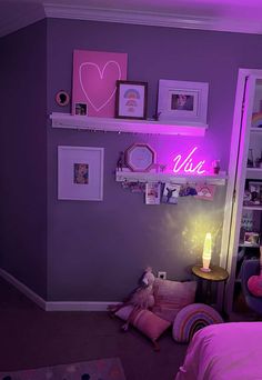 a bedroom with purple walls and pictures on the wall