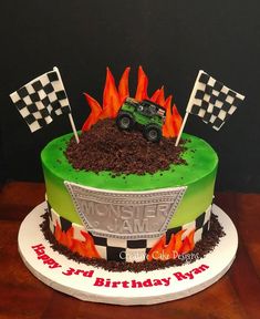 a birthday cake with a monster truck on top and flames coming out of the bottom