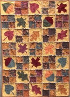 a quilt with leaves on it in the shape of squares