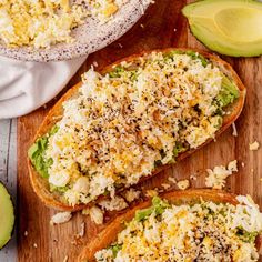 two pieces of bread with shredded cheese and avocado on the side