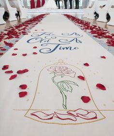 the aisle is decorated with red rose petals