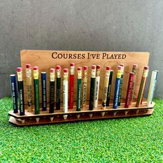 a group of pencils sitting on top of a wooden stand