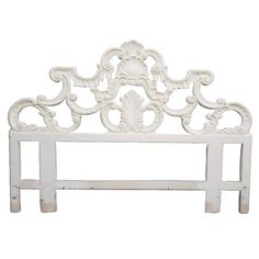 a white headboard with an ornate design on the top and bottom, against a white background