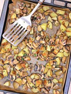 a pan filled with potatoes and mushrooms next to a spatula on top of it