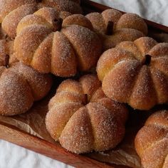 some sugared buns sitting on top of a wooden tray