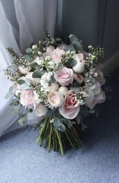 a bouquet of flowers sitting on top of a blue carpeted floor next to a window