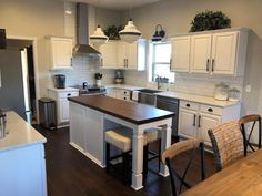 a large kitchen with white cabinets and wooden counter tops, along with an island in the middle