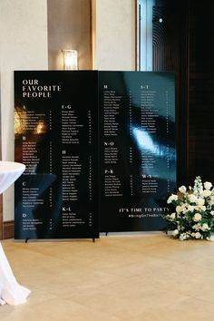 a table with white flowers on it next to a black and white sign