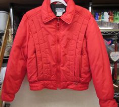 a red jacket hanging on a rack in a store