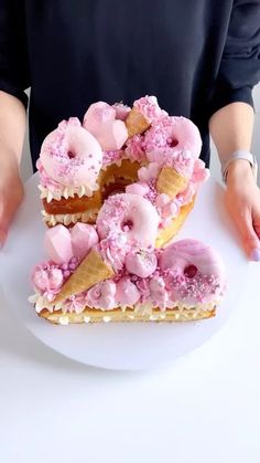 a white plate topped with pink donuts covered in frosting and sprinkles