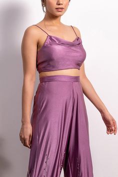 Purple crop top with cowl neckline and shoulder straps. Comes with high waisted embroidered pants.
Component: 2
Pattern: Embroidery
Type Of Work: Pearl, Sequin and Cutdana
Neckline: Cowl Neck
Sleeve Type: Sleeveless
Fabric: Lycra
Color: Purple
Other Details: 
Pants with embroidery on the hem
Shoulder straps
Closure: Side zip
Note: Blouse padded only up till size: 2XL
Occasion: Party - Aza Fashions Two-piece Cropped Party Tops, Cropped Two-piece Party Top, Cropped Two-piece Top For Party, Chic Crop Top Set For Party, Chic Party Crop Top Set, Cropped Two-piece Party Bottoms, Chic Party Sets With Crop Top, Party Cropped Two-piece Bottoms, Party Cropped Pants