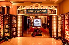 an entrance to a hollywood movie theater decorated with christmas lights and pictures on the walls