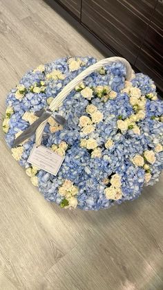 a basket filled with blue and white flowers on top of a wooden floor next to a counter