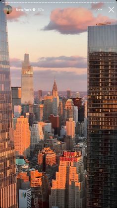 an aerial view of new york city with skyscrapers in the foreground at sunset