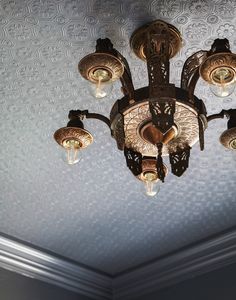 a chandelier hanging from the ceiling in a room with patterned walls and ceilings