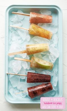 an ice tray filled with fruit and skewers