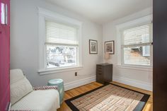 a living room with hardwood floors and white walls