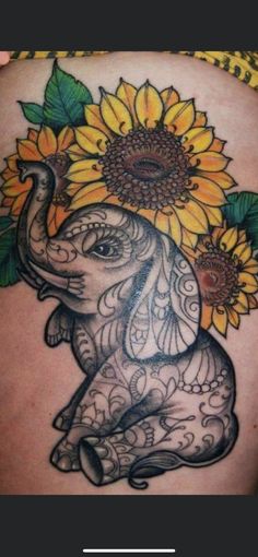 an elephant and sunflower tattoo on the back of a woman's stomach,