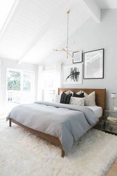 a bed room with a neatly made bed and pictures on the wall