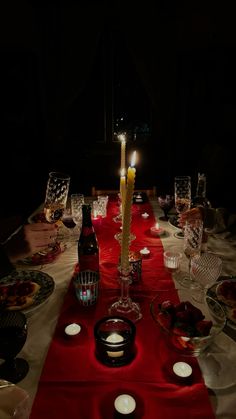 a long table with candles and plates on it