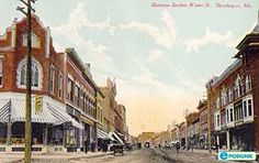 an old postcard shows people walking down the street