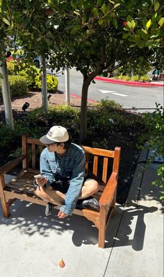 a man sitting on top of a wooden bench