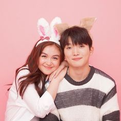 two people are posing for a photo with bunny ears on their heads and one is holding the other's head