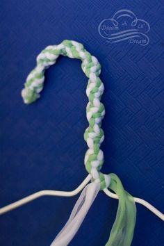 a green and white braided object on a blue surface with the string attached to it