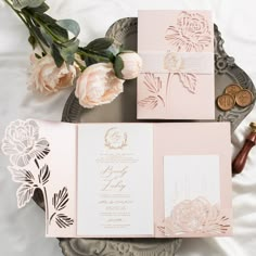 the wedding stationery is laid out on top of a plate with flowers in it