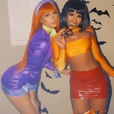 two women dressed in costumes posing for the camera