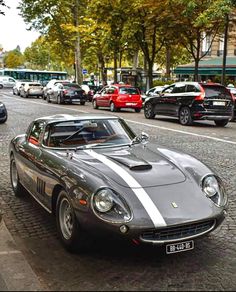 an old sports car is parked on the side of the street