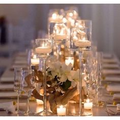 a long table with candles and flowers on it is set for an elegant dinner party