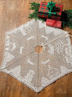 a crocheted doily with a christmas tree skirt and presents on the floor