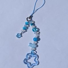 a blue and white beaded necklace hanging from a hook on a string with beads