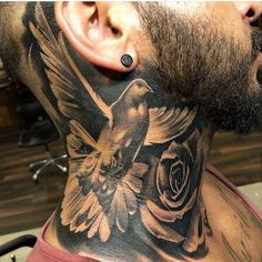 a man with a bird and flower tattoo on his neck