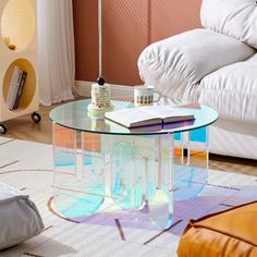 a glass table with a book on it in a living room next to a couch