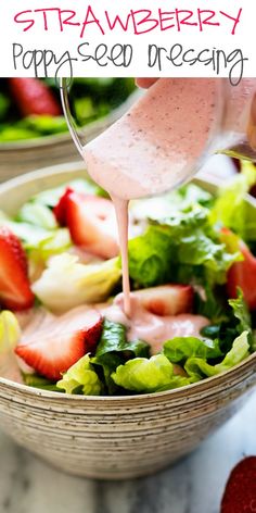 strawberry poppy seed dressing being poured into a bowl with strawberries and lettuce