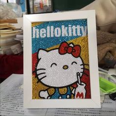 an image of a hello kitty painting on a table with other items in the background