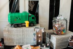 there is a green truck on top of newspaper boxes and other items in front of it