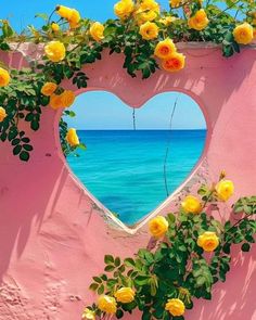 a heart shaped window with yellow roses growing out of it and the ocean in the background