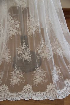 a white sheer curtain with lace on it