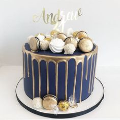 a blue and gold birthday cake with white frosting, chocolate candies, and sprinkles