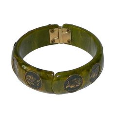 "Item: This is a spinach green bakelite clamper bangle with some nice marbling and little coins inset encircling the bracelet. The hinge works fine and I don't see any major scratching or chips. Tested and guaranteed vintage bakelite. Be sure to check our other listings for lots more bakelite jewelry! Measurements: 3/4\" wide - 2 1/2\" inner diameter, about 7 3/8\" inner circumference. Condition: 9 - Very good, slightly misaligned, otherwise in excellent condition. Shipping: Shipping in the U.S. Vintage Bakelite Bracelet, Vintage Bakelite Bangle Jewelry, Vintage Bakelite Bangle, Green Vintage Cuff Bracelet, Vintage Green Cuff Bracelet For Formal Events, Vintage Green Cuff Bracelet For Formal Occasions, Vintage Green Adjustable Cuff Bracelet, Green Vintage Cuff Bracelet For Formal Occasions, Green Vintage Formal Cuff Bracelet