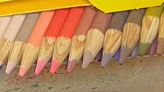 many colored pencils are lined up in a row